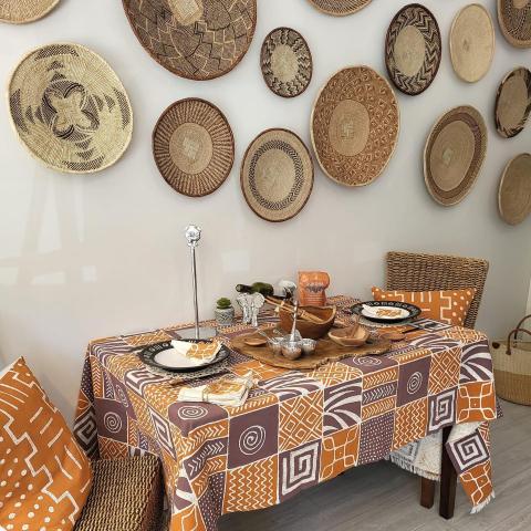 handmade, fairtrade textiles from Zimbabwe, this photo shows a table runner, and a variety of baskets hanging on the wall